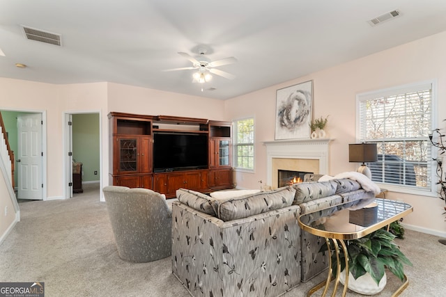 carpeted living room with plenty of natural light and ceiling fan