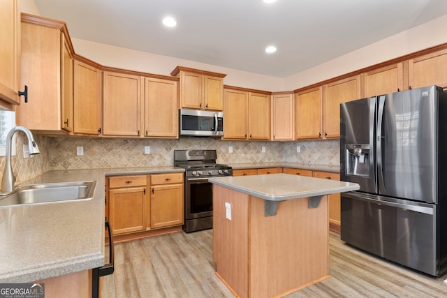 kitchen featuring decorative backsplash, stainless steel appliances, sink, light hardwood / wood-style floors, and a kitchen island