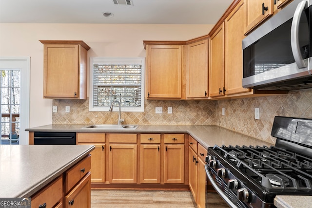 kitchen with sink, backsplash, light hardwood / wood-style flooring, and black appliances