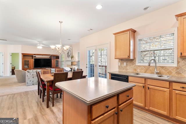 kitchen with decorative backsplash, sink, a center island, and light wood-type flooring