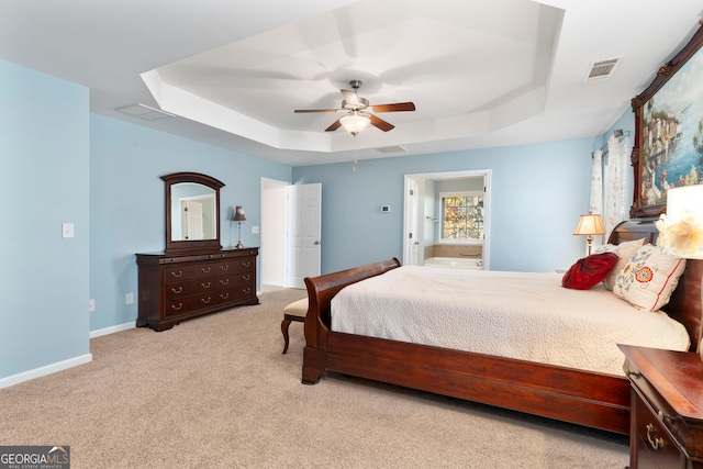 bedroom featuring a raised ceiling, ceiling fan, and light colored carpet