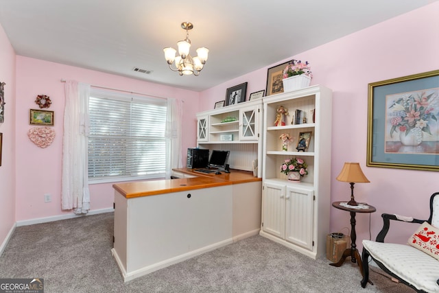 carpeted home office with an inviting chandelier