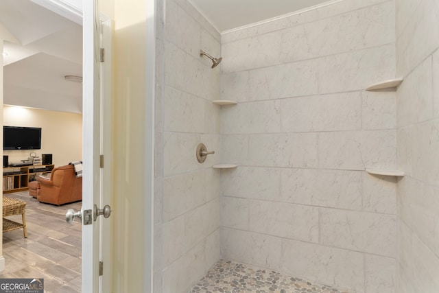 bathroom featuring hardwood / wood-style floors and tiled shower