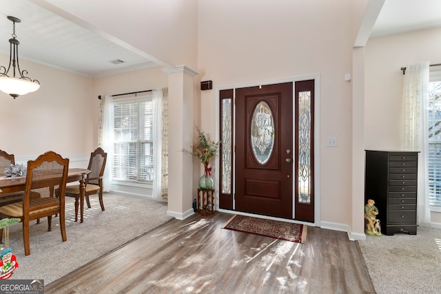 entrance foyer featuring a healthy amount of sunlight, wood-type flooring, and ornamental molding