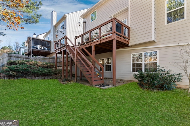 rear view of house featuring a wooden deck and a yard