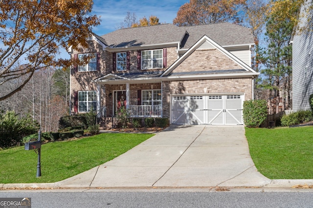 view of front of house featuring covered porch, a front yard, and a garage