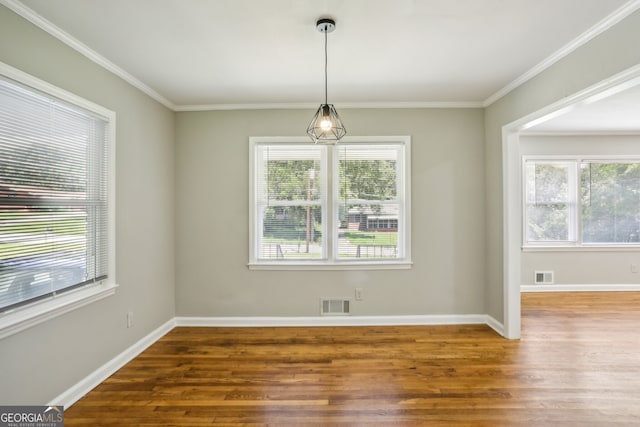 unfurnished dining area with a wealth of natural light, hardwood / wood-style floors, and crown molding