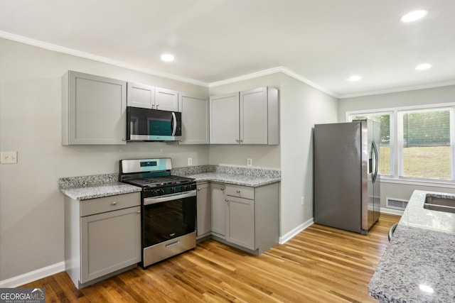 kitchen featuring appliances with stainless steel finishes, light hardwood / wood-style floors, and gray cabinets