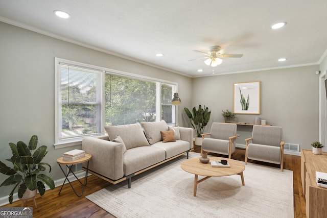 living room with hardwood / wood-style flooring, ceiling fan, and crown molding