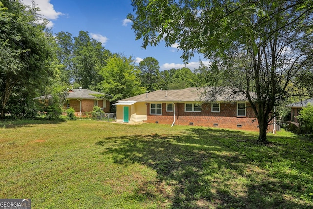 rear view of house featuring a lawn