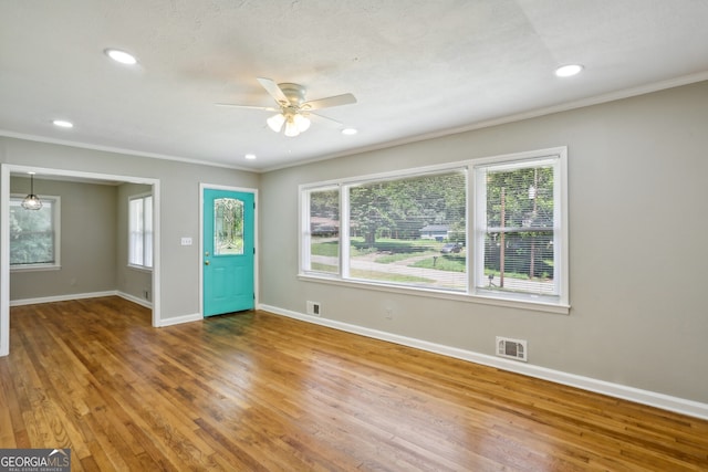 entrance foyer featuring crown molding, ceiling fan, hardwood / wood-style floors, and a healthy amount of sunlight