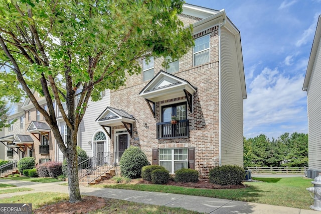 view of front of property with a front yard and central AC unit