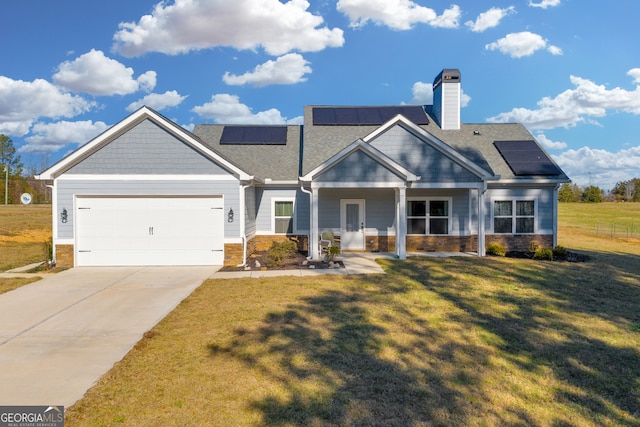 craftsman house featuring a front yard, solar panels, and a garage