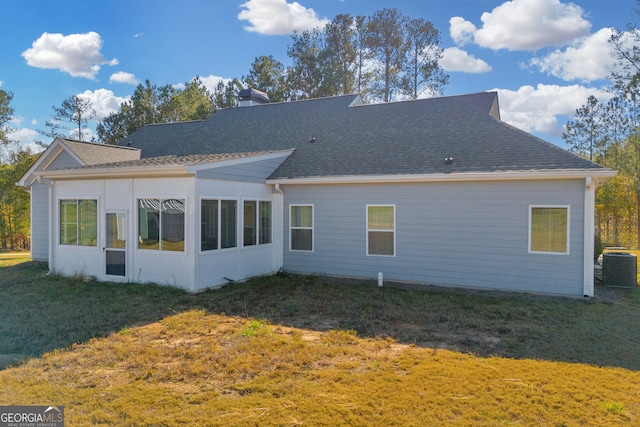 rear view of house with a yard and central air condition unit