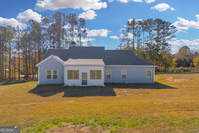 rear view of property featuring a yard