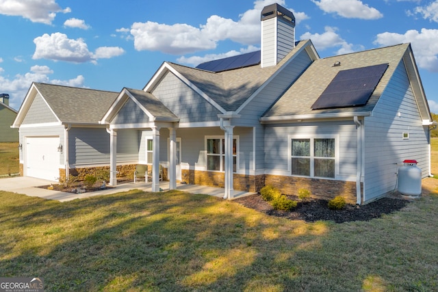 view of front of home with solar panels, a garage, and a front lawn