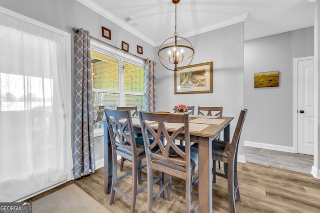 dining room featuring crown molding, wood-type flooring, and an inviting chandelier