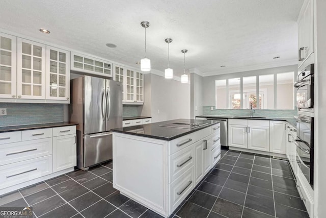 kitchen featuring backsplash, white cabinetry, crown molding, and appliances with stainless steel finishes