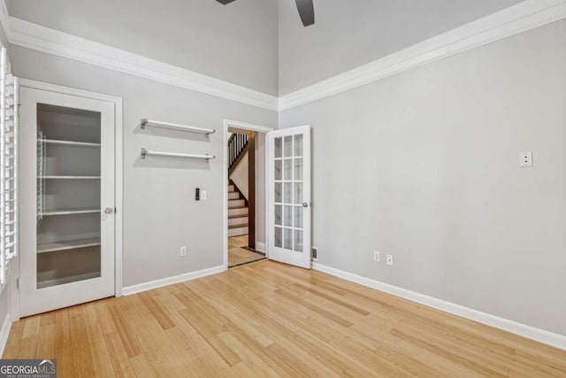 spare room featuring hardwood / wood-style flooring, ceiling fan, crown molding, and french doors