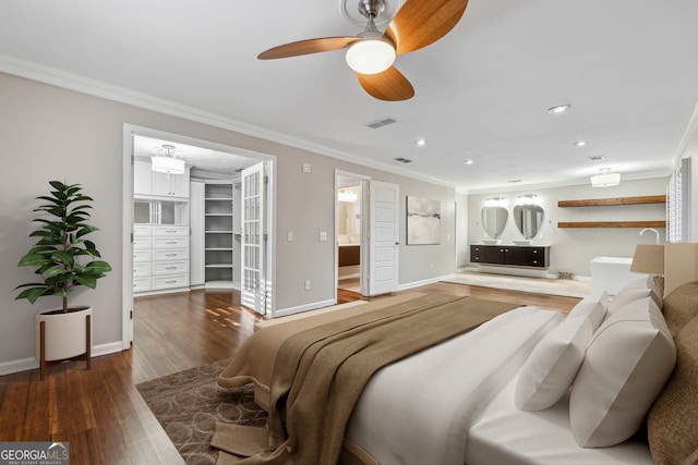 bedroom featuring ceiling fan, crown molding, a spacious closet, and dark wood-type flooring