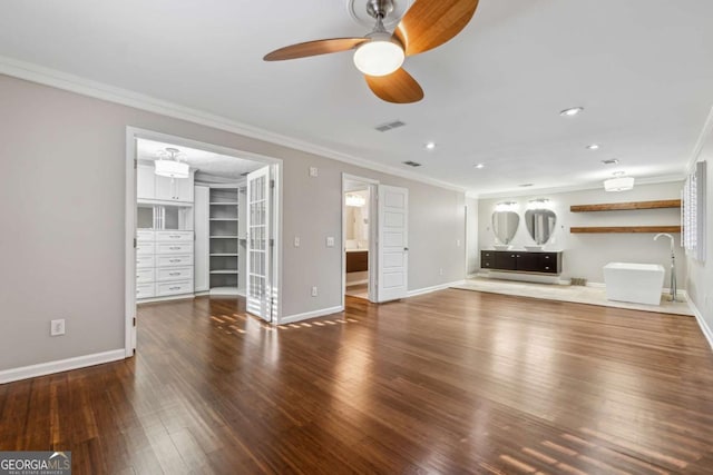 unfurnished living room featuring dark hardwood / wood-style flooring, ceiling fan, and ornamental molding