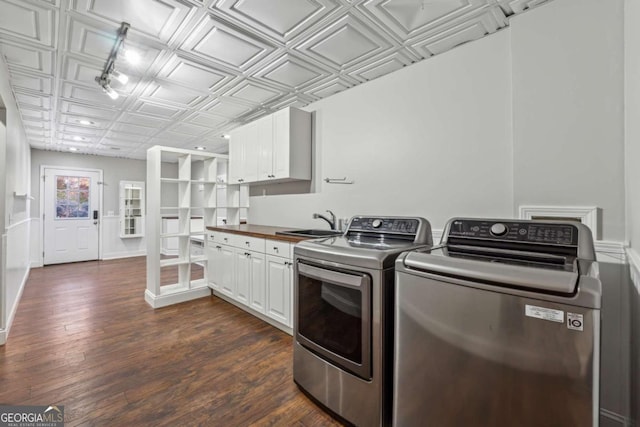 laundry room with dark hardwood / wood-style floors, washer and dryer, cabinets, and sink