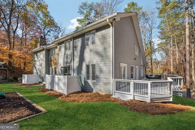 rear view of house featuring a yard and a wooden deck