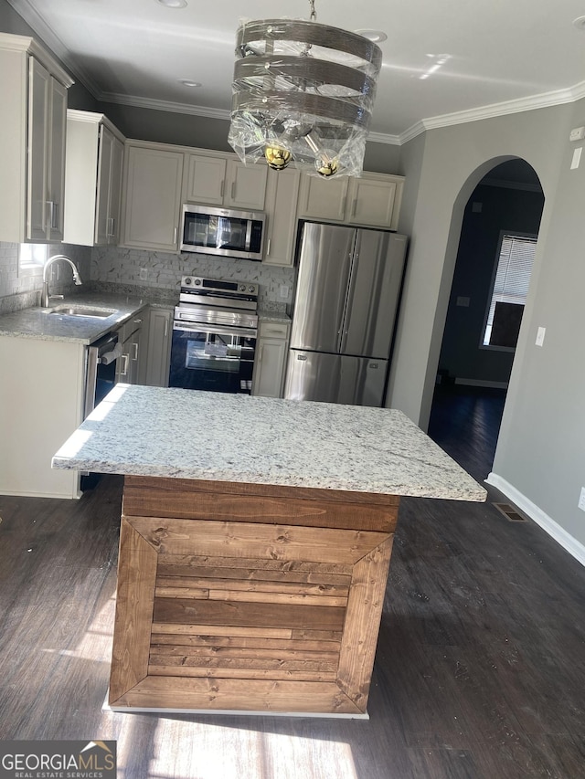 kitchen featuring appliances with stainless steel finishes, a center island, dark hardwood / wood-style floors, and gray cabinets