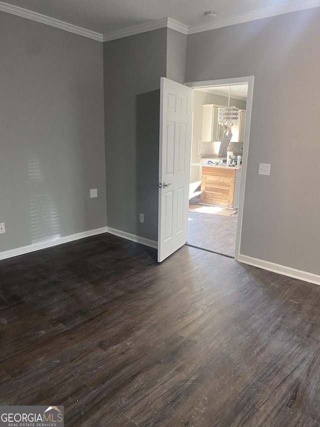 unfurnished room with dark hardwood / wood-style flooring, a chandelier, and ornamental molding