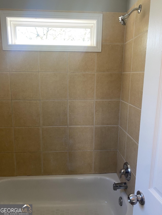 bathroom featuring tiled shower / bath combo and a wealth of natural light