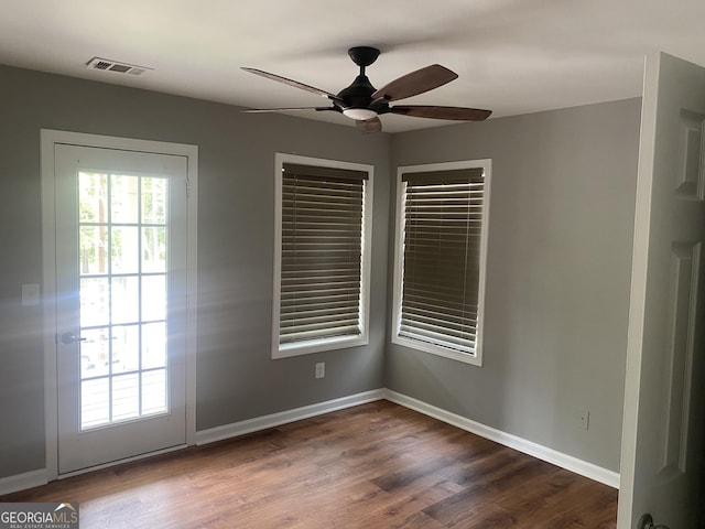 unfurnished room with ceiling fan and dark wood-type flooring