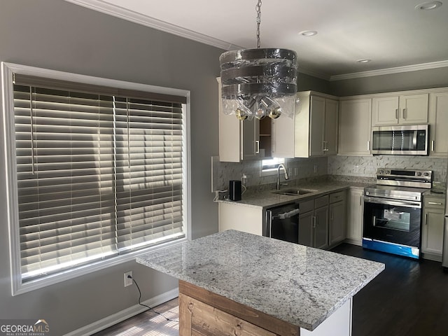 kitchen featuring ornamental molding, stainless steel appliances, sink, dark hardwood / wood-style floors, and hanging light fixtures