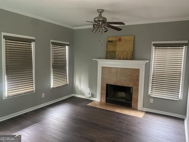 unfurnished living room with a fireplace, ceiling fan, ornamental molding, and dark wood-type flooring