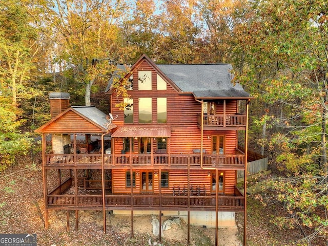 back of house with a balcony, a deck, and french doors