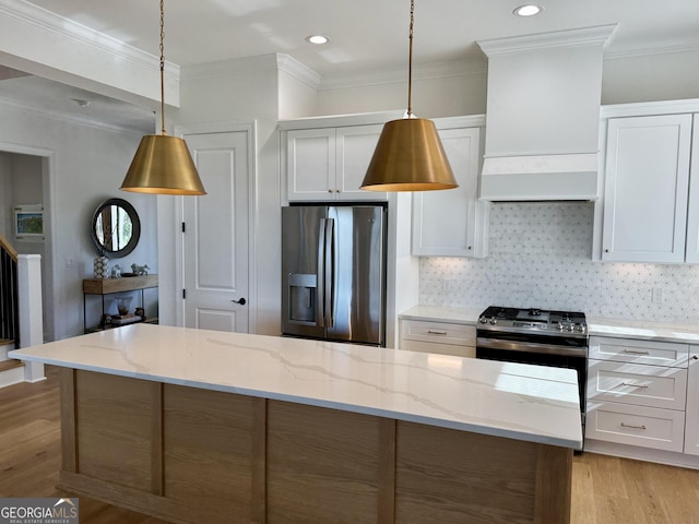 kitchen featuring white cabinetry, light stone counters, stainless steel fridge, decorative light fixtures, and light wood-type flooring