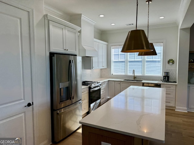 kitchen featuring appliances with stainless steel finishes, dark hardwood / wood-style flooring, a kitchen island, white cabinetry, and hanging light fixtures