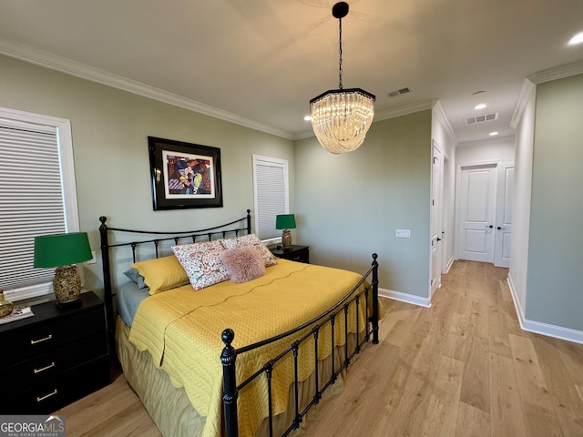 bedroom featuring ornamental molding, light hardwood / wood-style floors, and an inviting chandelier