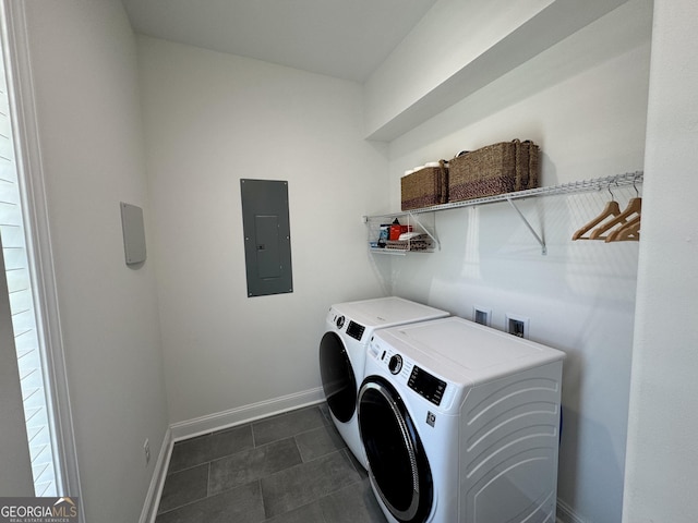 laundry area with washing machine and dryer, electric panel, and dark tile patterned flooring