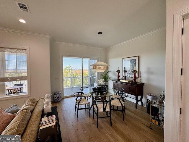 dining area featuring hardwood / wood-style flooring and ornamental molding