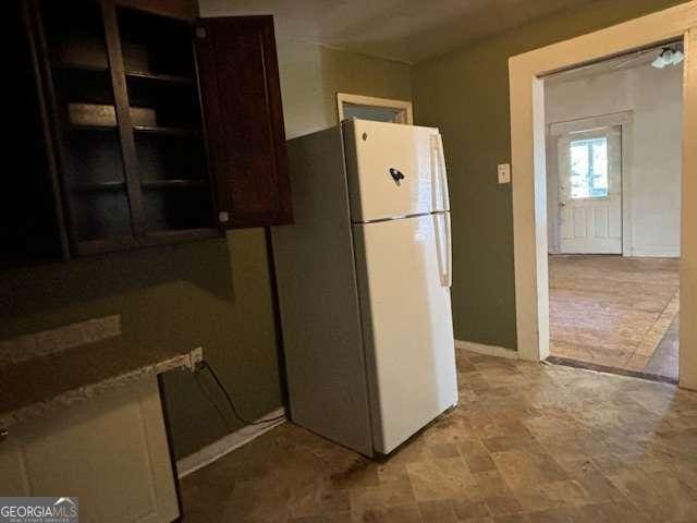 kitchen featuring dark brown cabinetry and white refrigerator