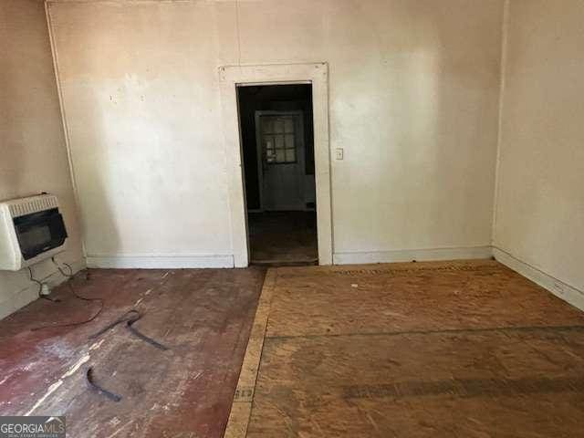 unfurnished room with heating unit