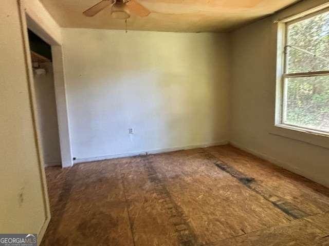 empty room featuring ceiling fan and plenty of natural light