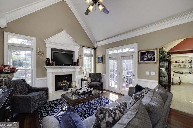 living room with ceiling fan, plenty of natural light, and ornamental molding