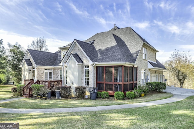 exterior space with a yard, a garage, and a sunroom