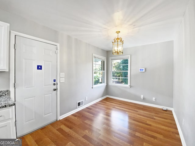 foyer entrance featuring hardwood / wood-style floors and a chandelier