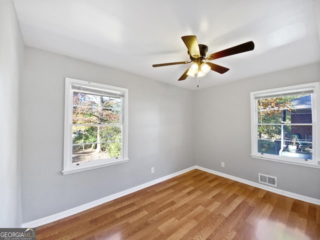 empty room with ceiling fan and hardwood / wood-style flooring