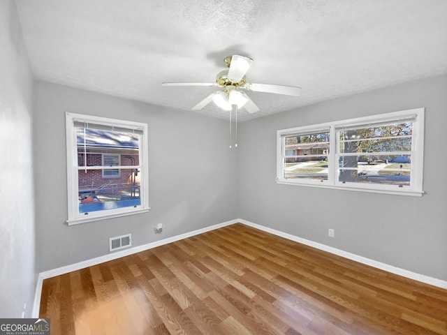 spare room with wood-type flooring, a textured ceiling, and ceiling fan