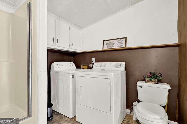 clothes washing area with washing machine and dryer, a textured ceiling, and ornamental molding