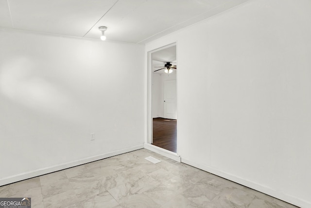 empty room featuring ceiling fan and crown molding