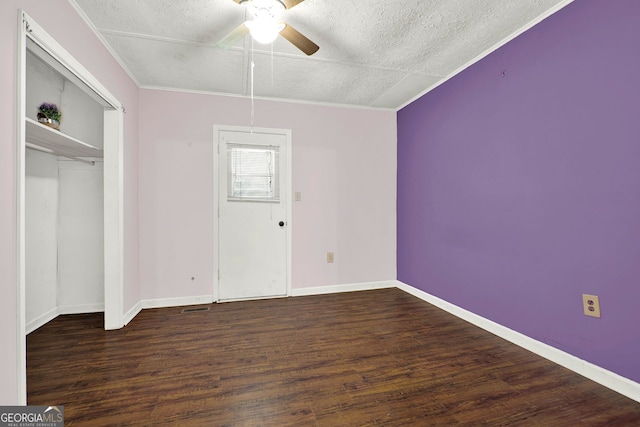 unfurnished bedroom featuring crown molding, ceiling fan, a textured ceiling, dark hardwood / wood-style flooring, and a closet